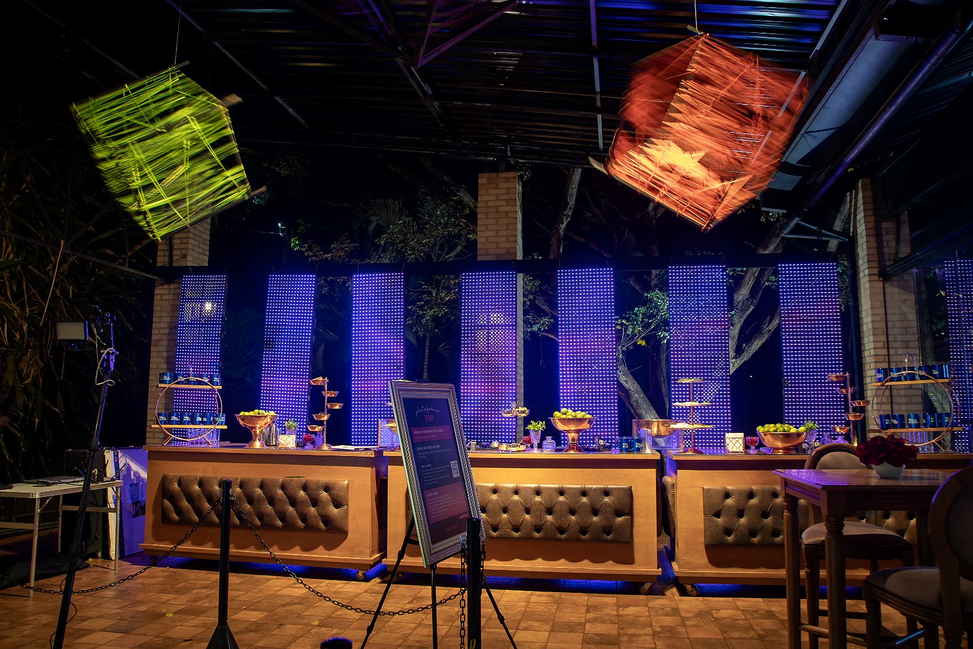 Bar com iluminação azul e banquetas na Villa do Lago
