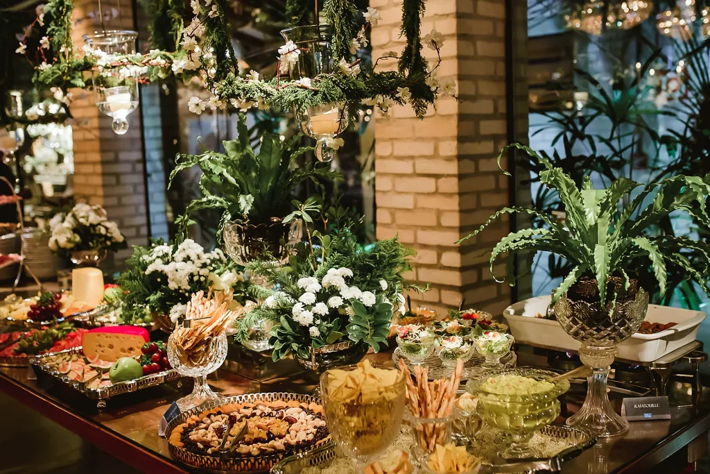 Estação de buffet decorada com flores no salão da Villa do Lago