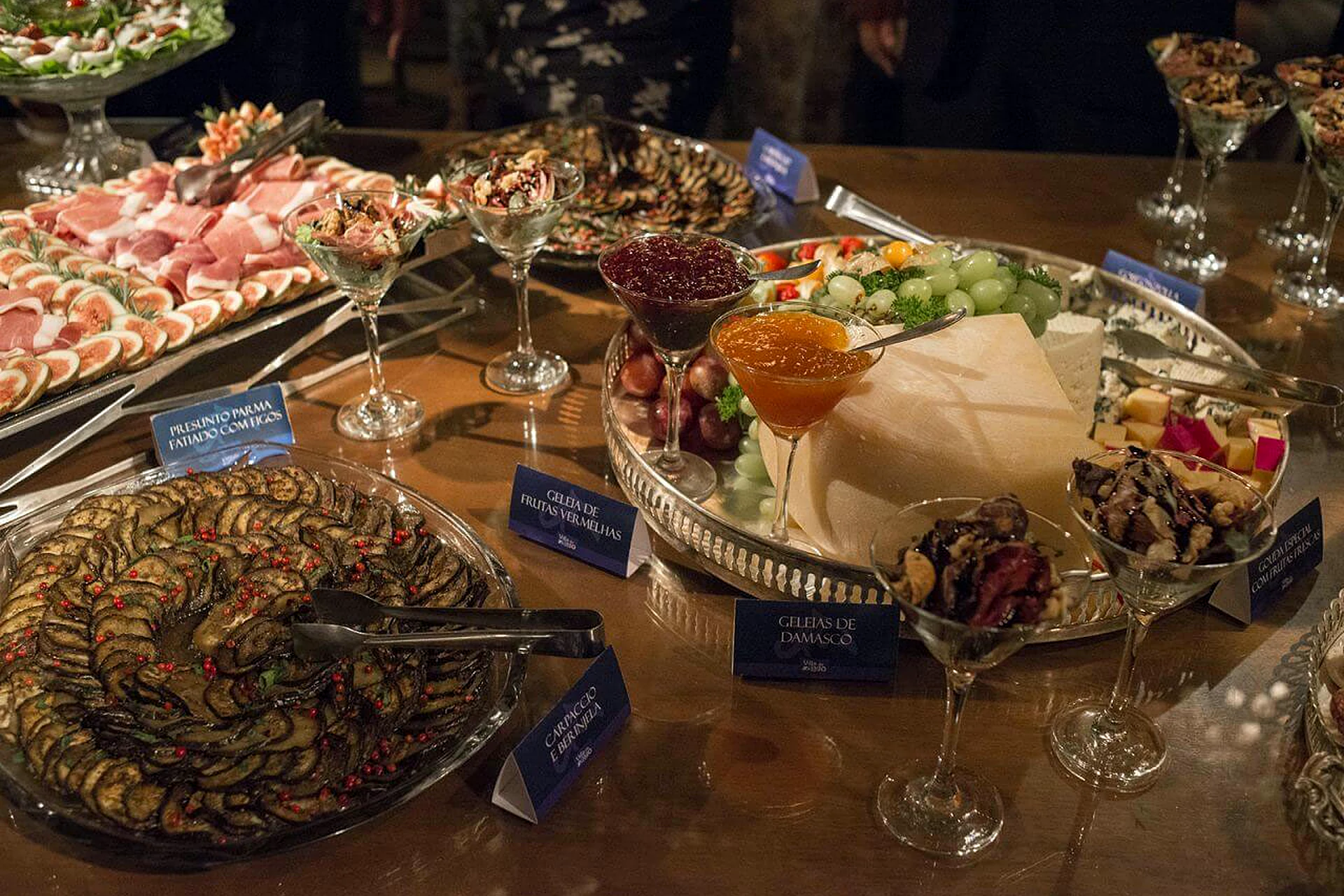 Mesa de frios com queijos, pães e antepastos na Villa do Lago