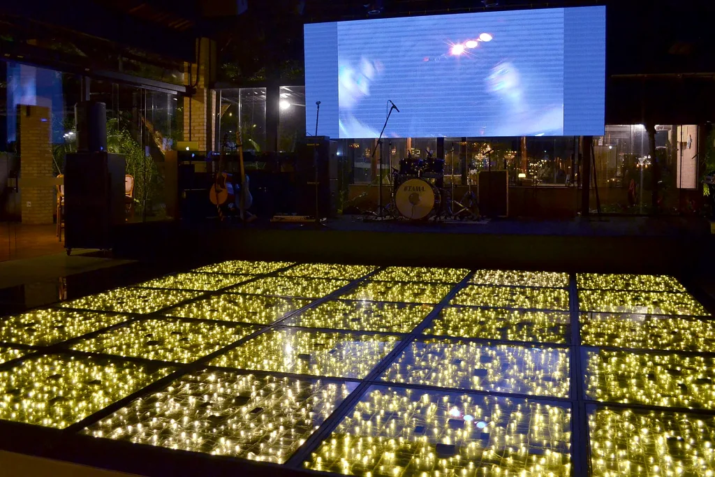 Pista de dança da Villa do Lago com piso iluminado e telão