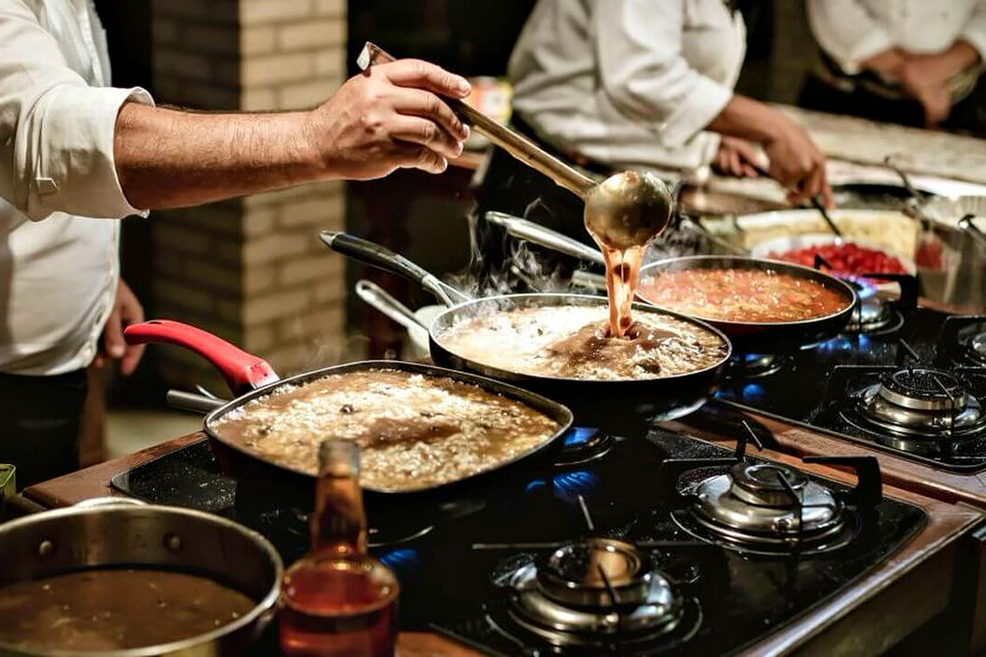 Cozinheiro finalizando prato ao vivo em estação gastronômica da Villa do Lago