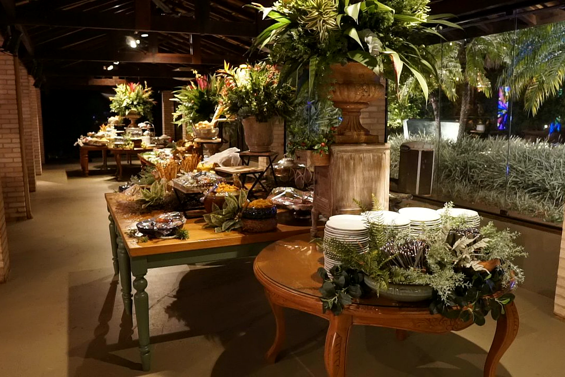 Salão da Villa do Lago com mesas de buffet decoradas com plantas e mesas para convidados